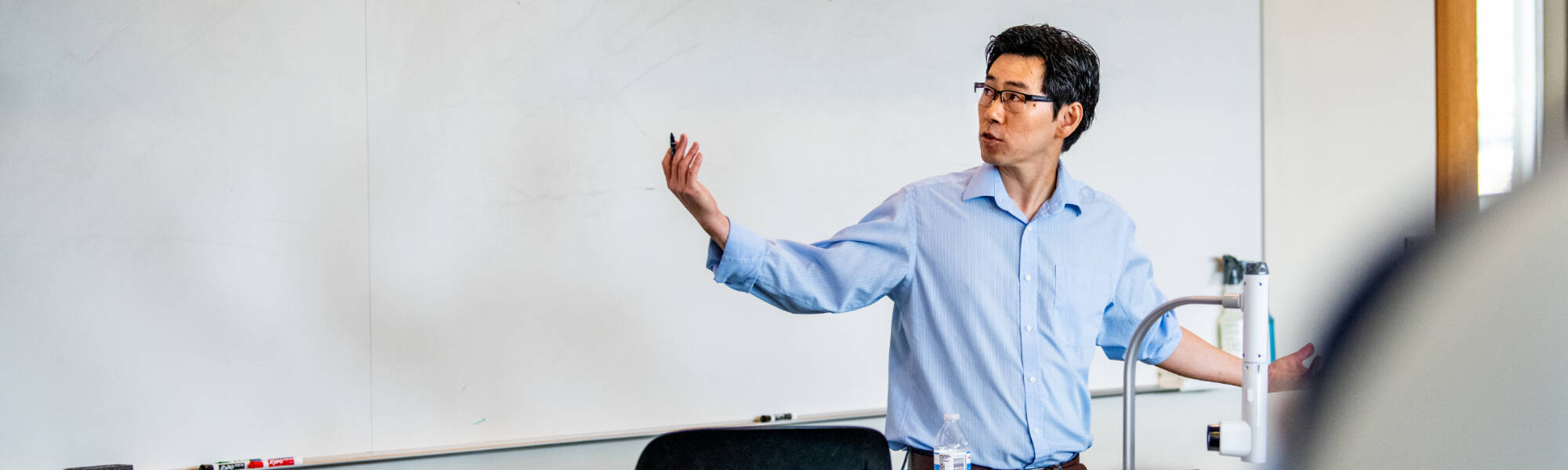 Laudo Ogura teaching in front of a whiteboard